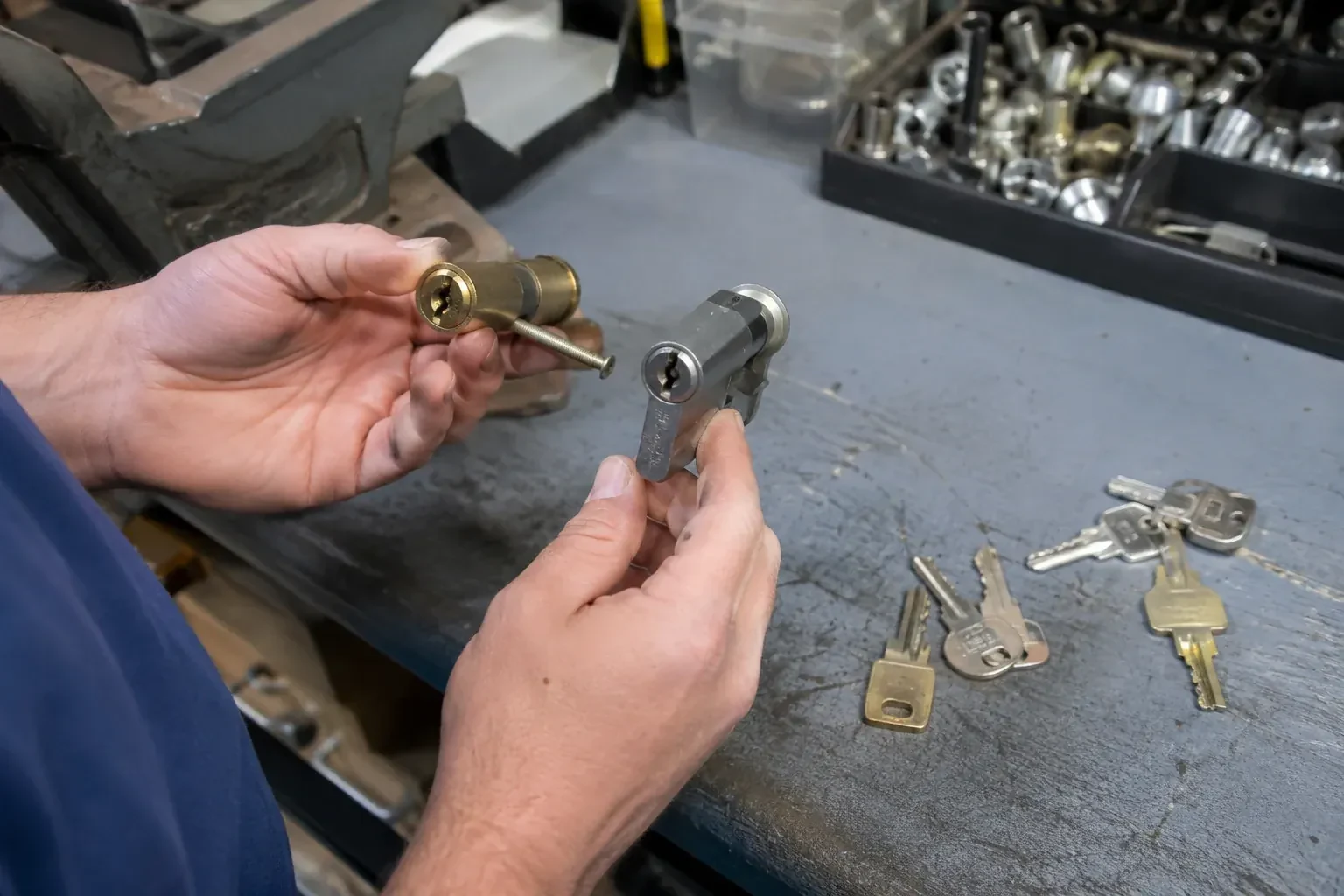 Hands comparing detached lock cylinders beside loose keys on a workbench. — Broken Key Extraction, Haldimand County